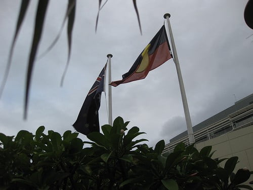The Australian national and aboriginal flags flying in the winter sky.