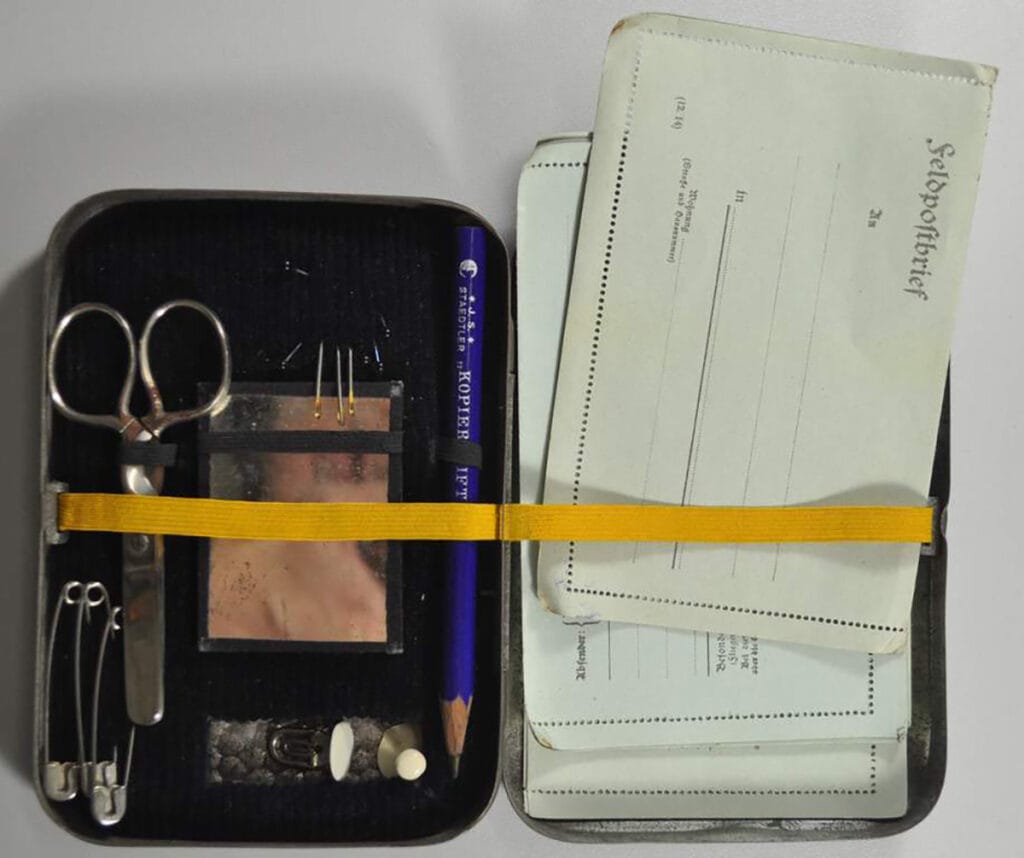 First Wolrd War tin containing a sewing kit and field postal stationery