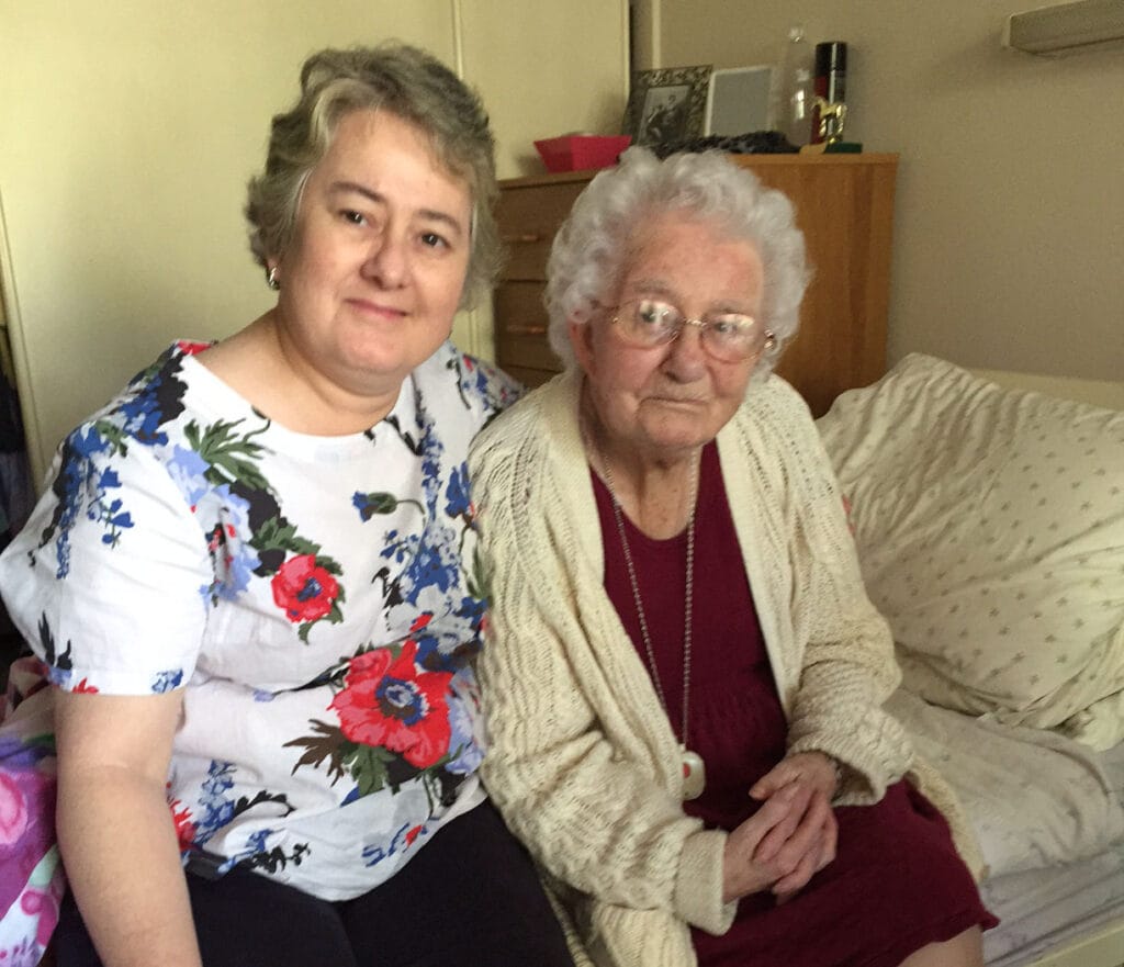 a middle aged woman sitting with an elderly woman