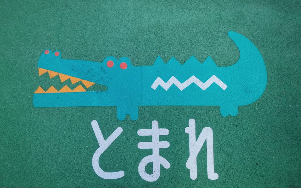 A crocodile painted ground with the Japanese word for Stop
