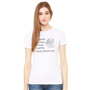 White women's fit t-shirt on model features image of a woman holding two thumbs up with the Martha Rosette Lutz quote "the opposite of winning isn't losing, it's quitting.